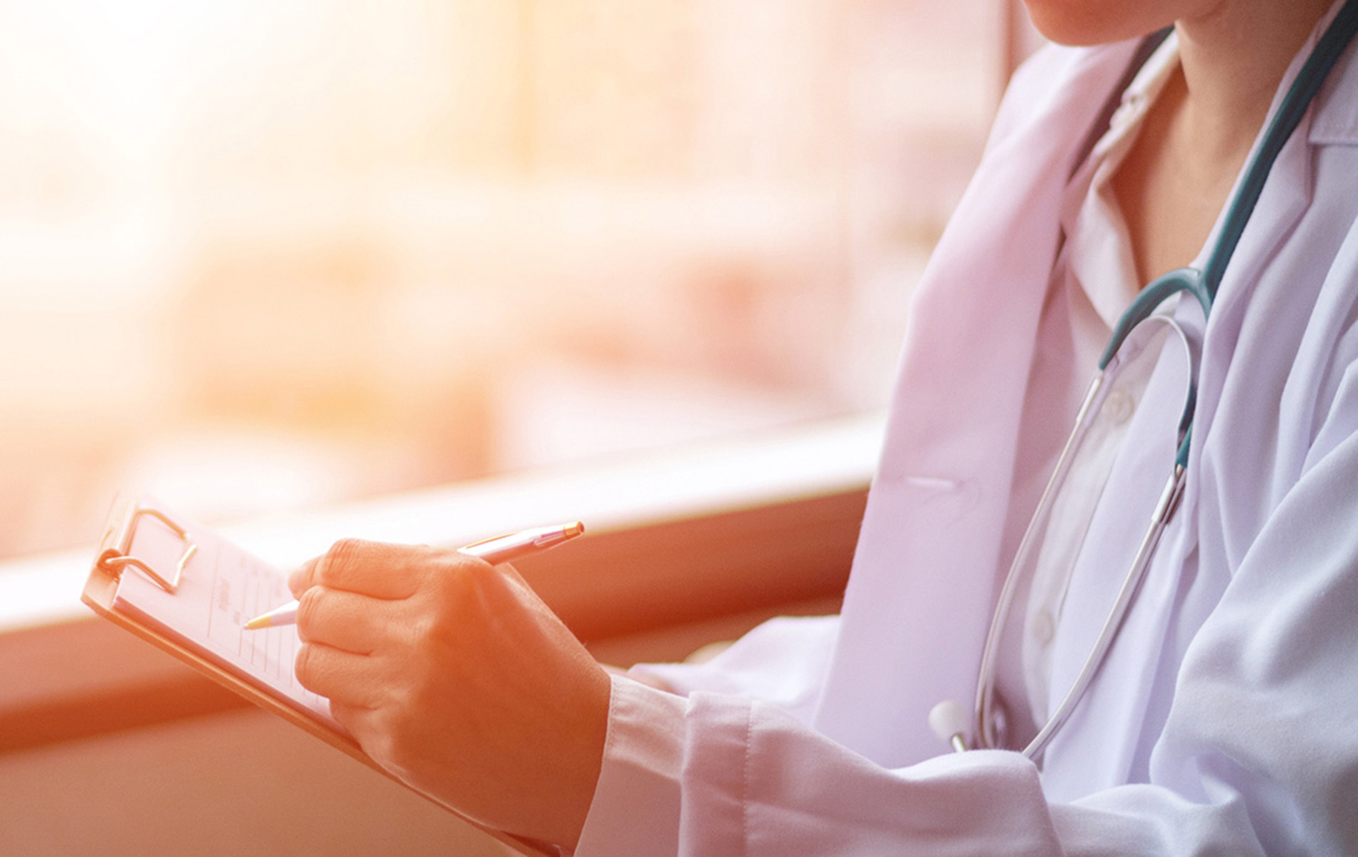 A female health care professional showing something on a notepad to a woman.