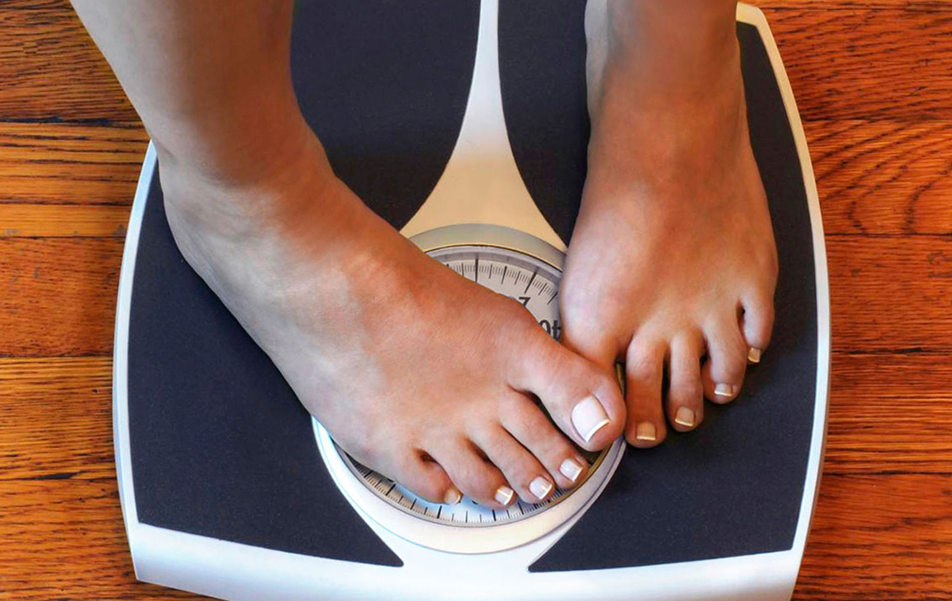 Die Füße einer Frau, die auf einem Gewicht stehen.